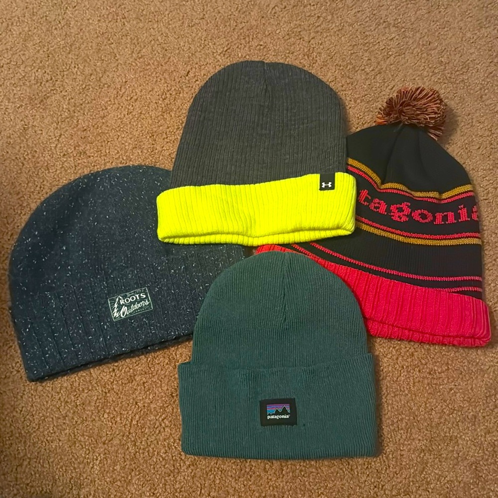 4 winter hats. Brands include 1- Roots  2- Patagonia 1- Under Armor